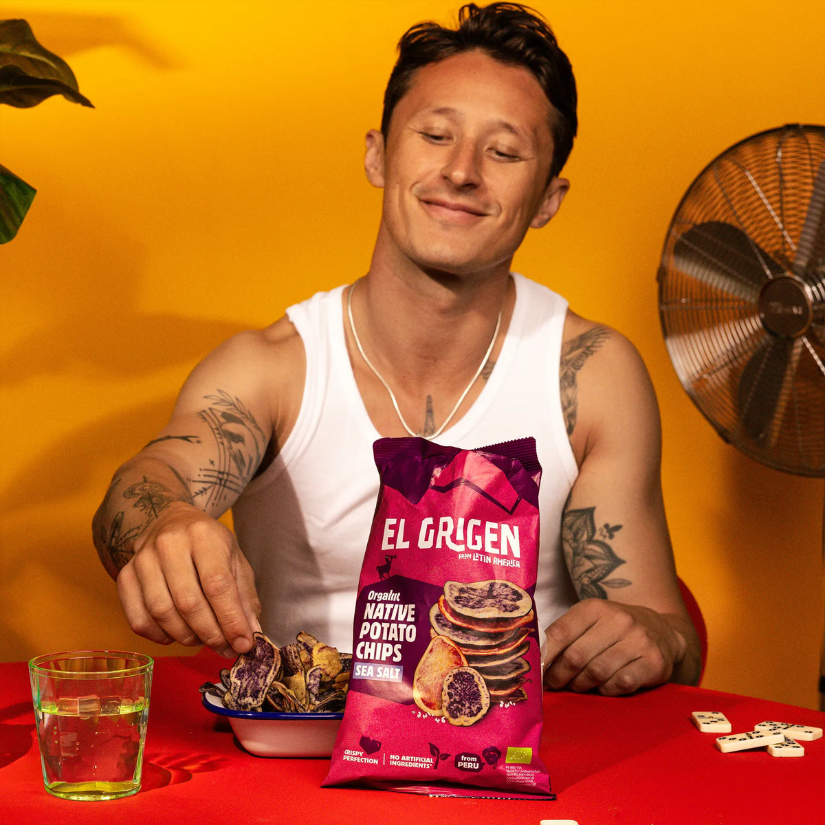 Mann greift in eine Schale bunte Native Potato Chips neben der el origen Packung – Snackmoment